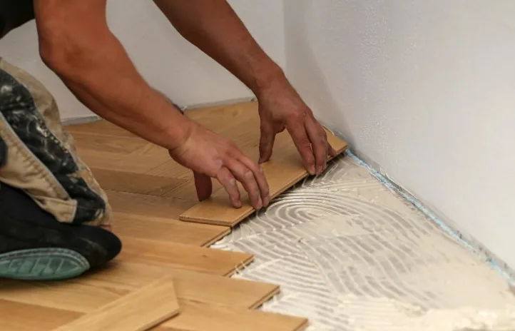 Colocación de piezas de efecto madera en espiga sobre cemento cola peinado con llana dentada